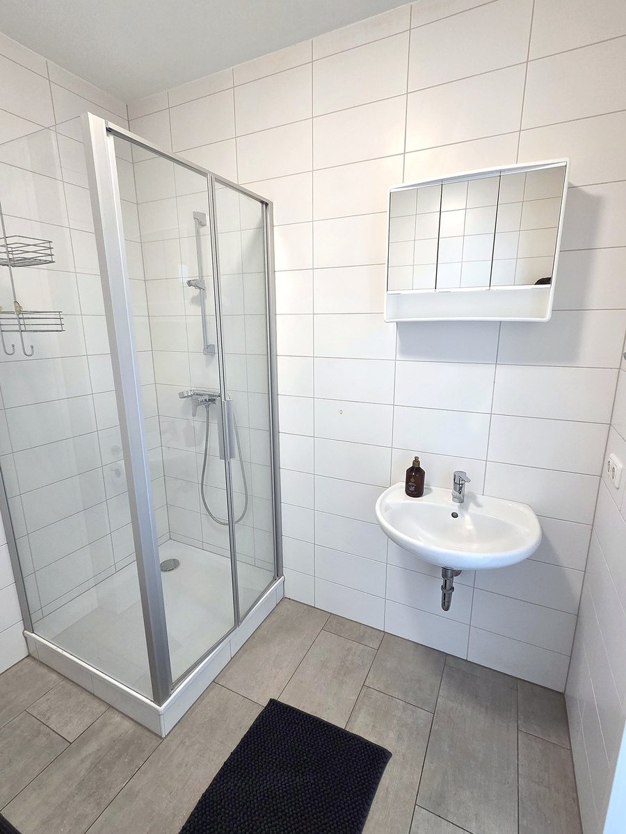 Bad mit Dusche, Waschbecken und Spiegelschrank